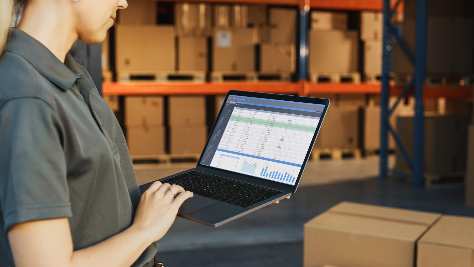 Image of a warehouse manager checking stock levels on her laptop