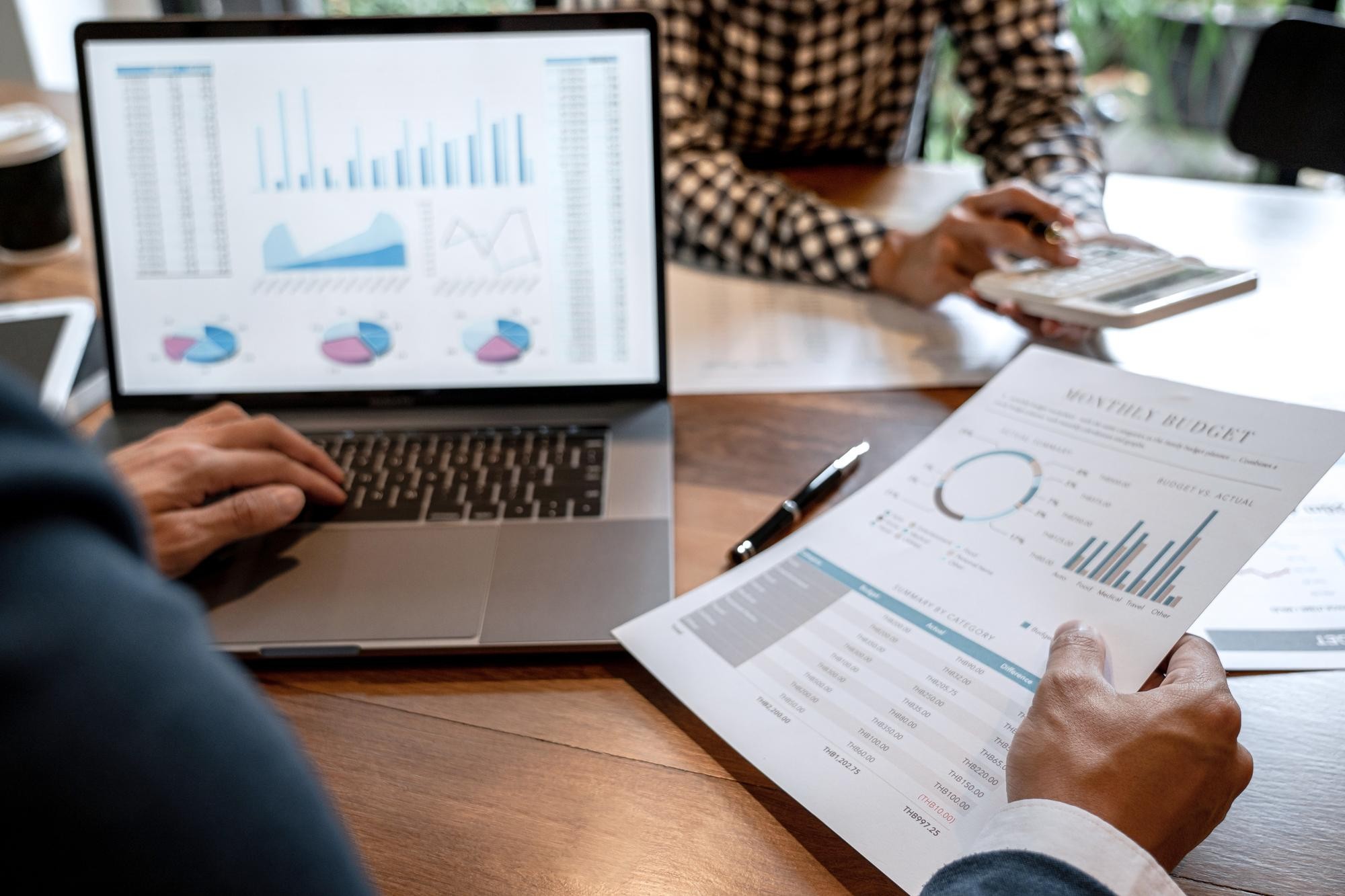Symbolic image depicting employees collecting and analyzing KPIs in the form of graphs and diagrams