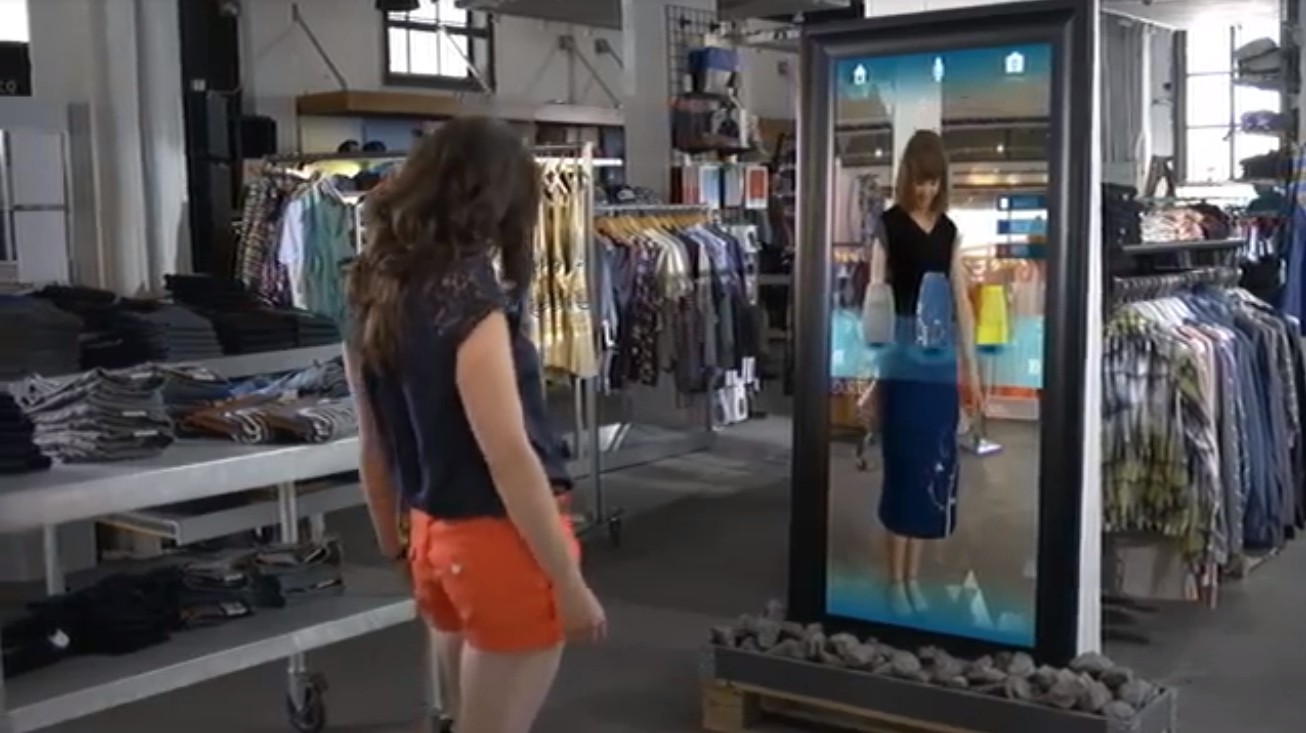 A woman trying on clothes virtually. Source: The Future of Augmented Reality: 10 Awesome Use Cases, https://www.youtube.com/watch?v=WxzcD04rwc8