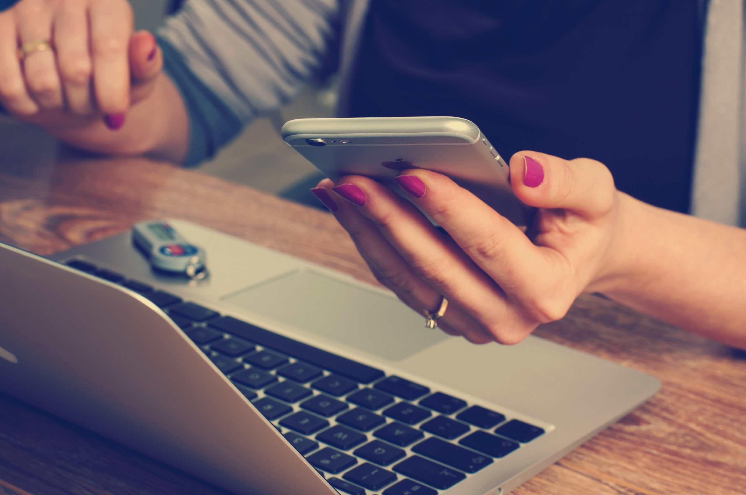 Picture of a woman working with a smartphone, a digital key generator and a laptop