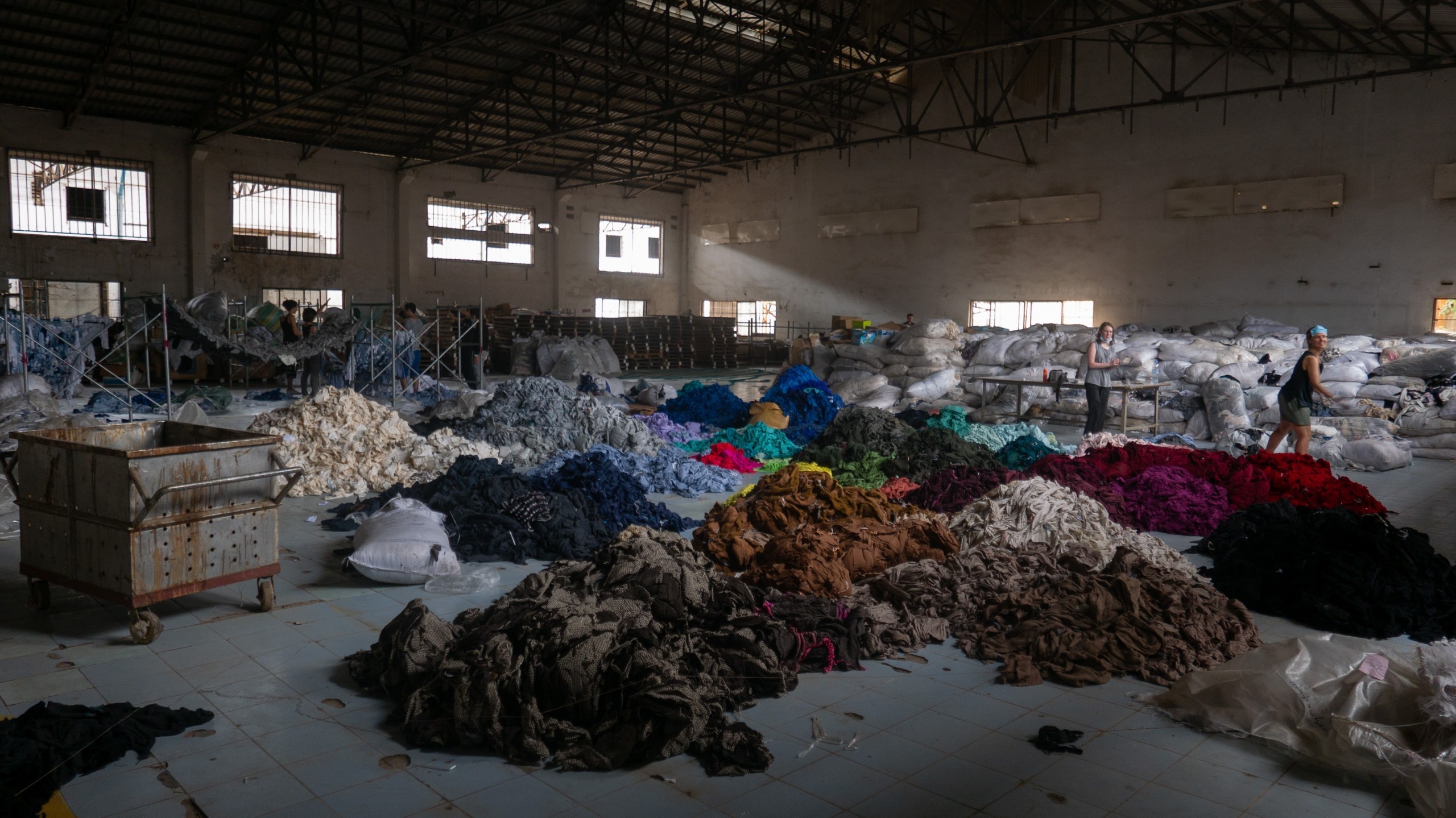 Image of people sorting through clothing in a warehouse